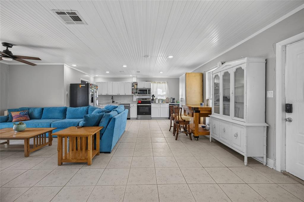 An open-concept living room and kitchen with white beadboard ceilings and light tile flooring — 22080 MIDWAY BOULEVARD, PORT CHARLOTTE, FL