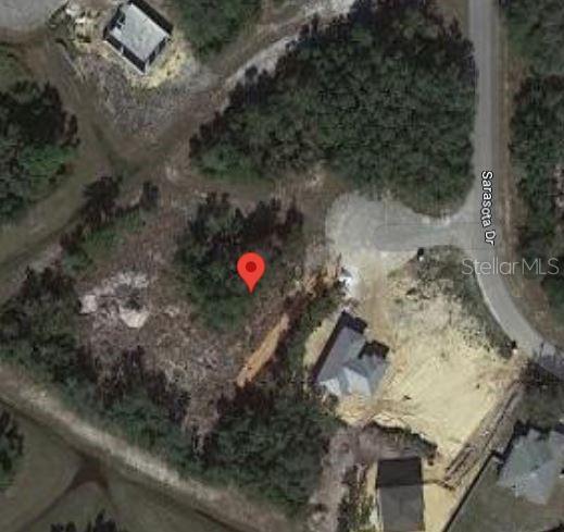 This aerial map view shows a vacant, wooded residential lot located next to existing homes — 506 SARASOTA PLACE, POINCIANA, FL