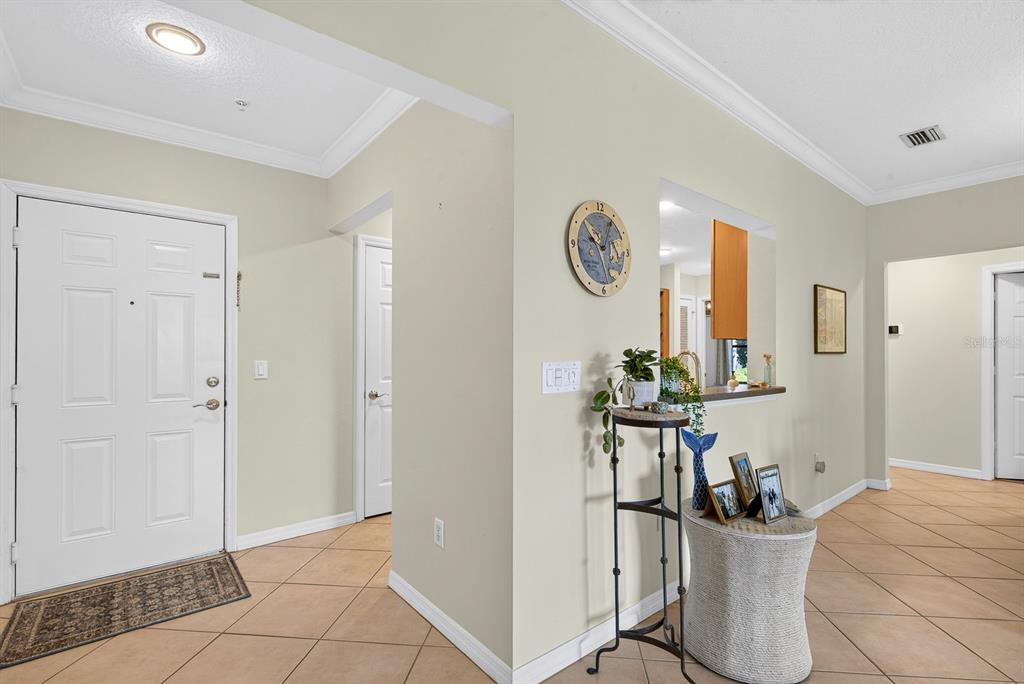 An entryway with tile flooring, a white front door, and a wall-mounted clock — 7228 HAMILTON ROAD UNIT 7228, BRADENTON, FL