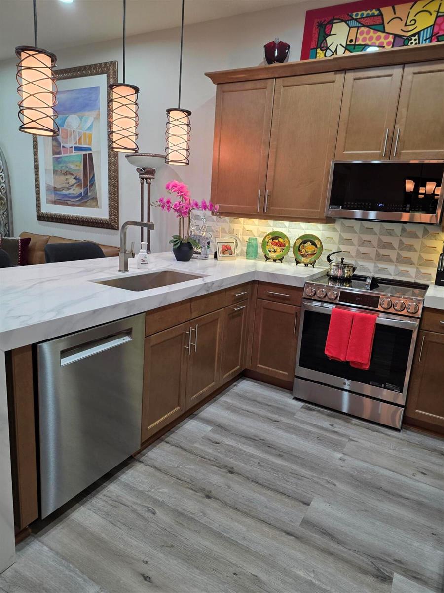A single-story house exterior features a paved driveway, two garage doors, and landscaped front gardens — 14748 Barletta Way, Delray Beach FL 33446, DELRAY BEACH, FL