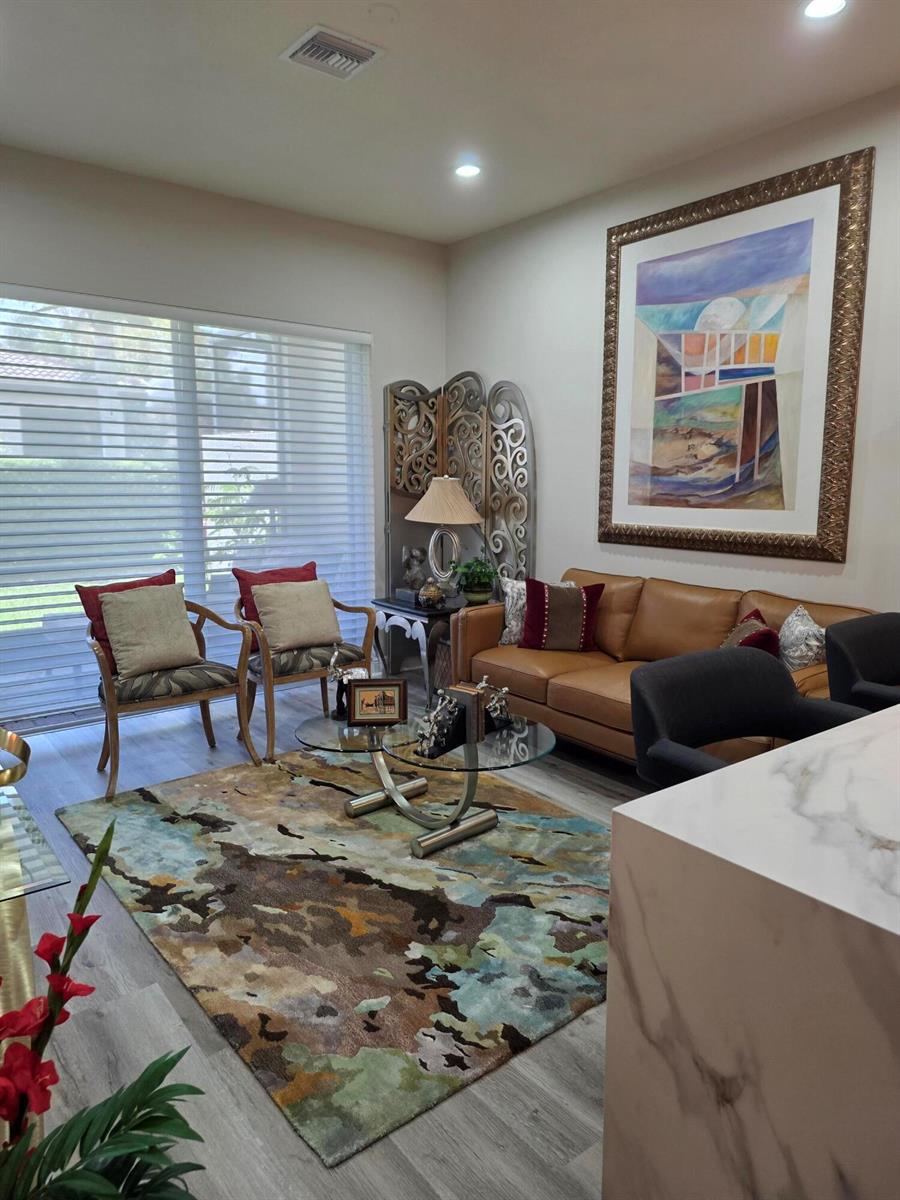 A kitchen with wood cabinets, marble-look countertops, and stainless steel appliances opens to a patio — 14748 Barletta Way, Delray Beach FL 33446, DELRAY BEACH, FL