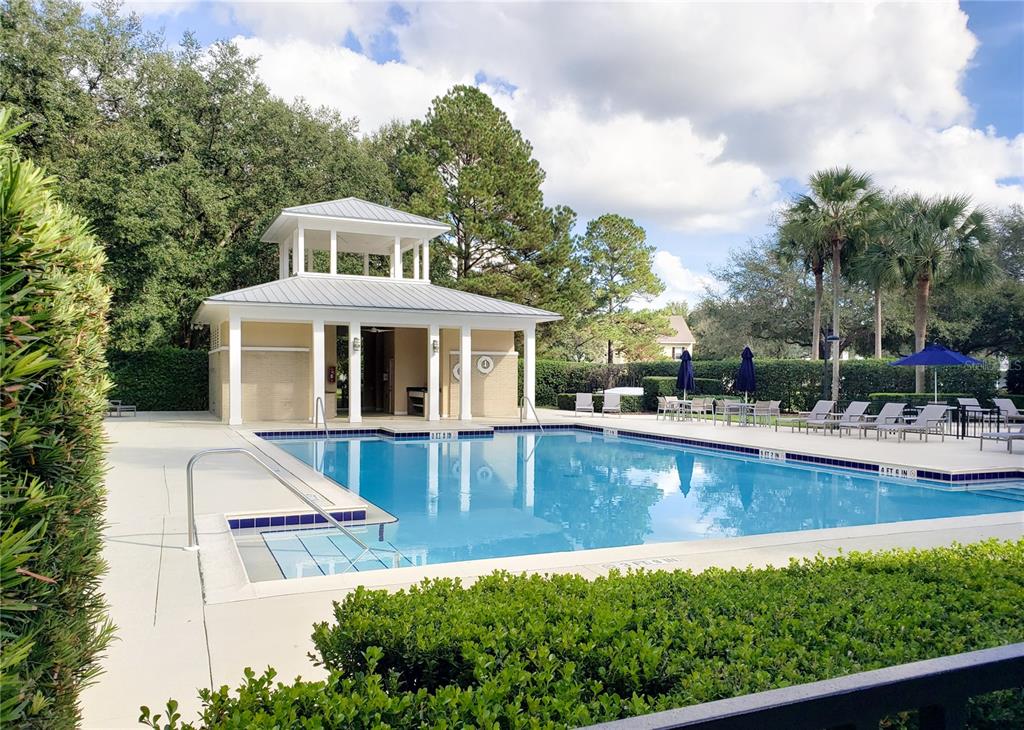 A rectangular swimming pool features a covered pavilion and lounge chairs on a sunny day — 13660 SW 8TH AVENUE, NEWBERRY, FL