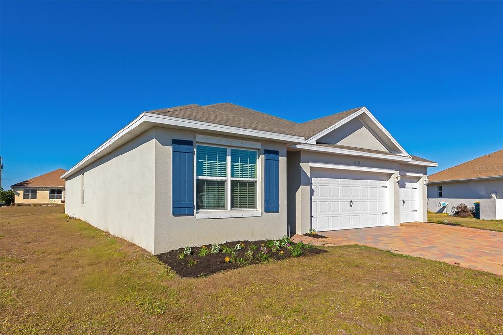 A modern kitchen features white cabinets, stainless steel appliances, and a central island with seating — 27131 GUAPORE DRIVE, PUNTA GORDA, FL