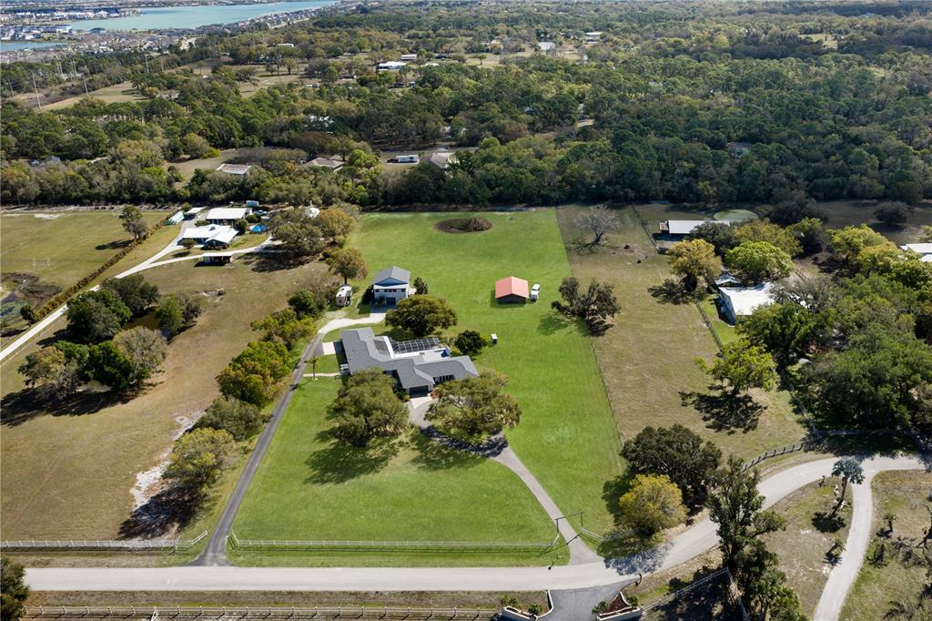 An aerial view shows a rural property with multiple houses, outbuildings, and large grassy fields — 1516 FOX CREEK DRIVE, SARASOTA, FL