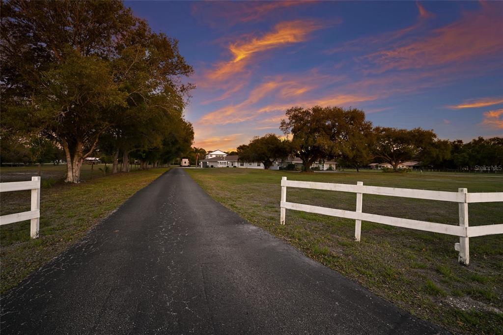 An aerial view shows a house with a pool, a barn, and trees on acreage — 1516 FOX CREEK DRIVE, SARASOTA, FL