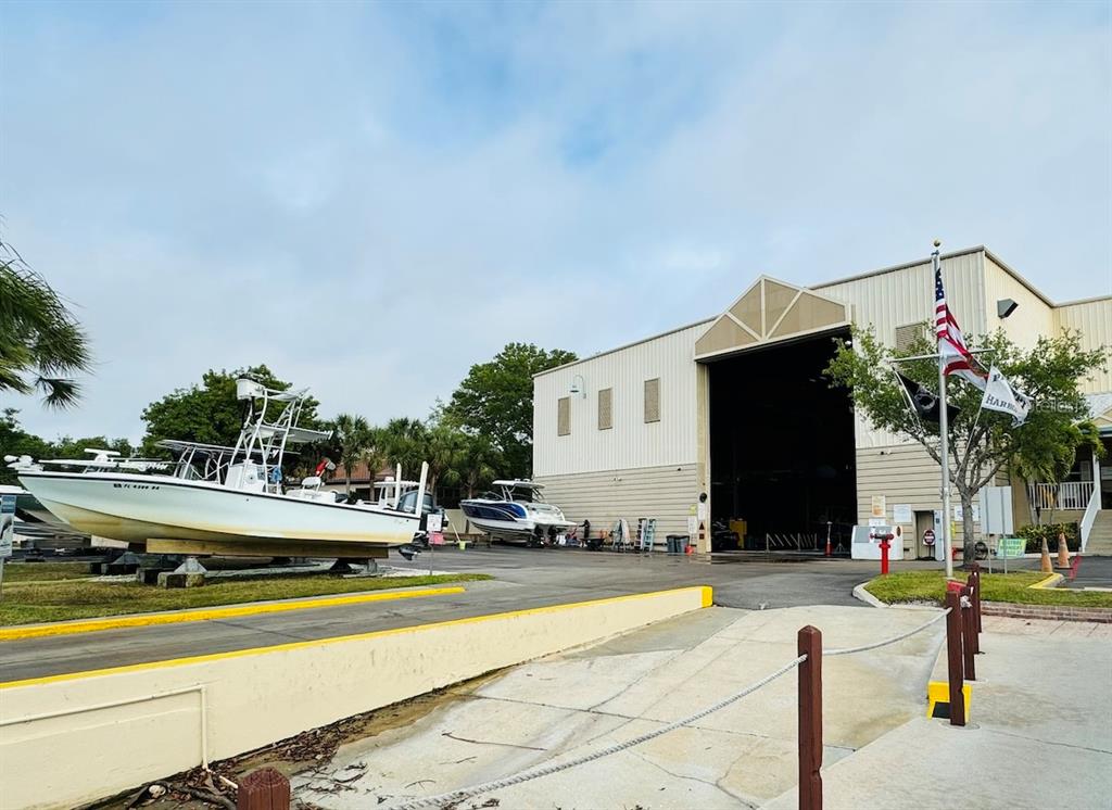 A large metal warehouse building stands next to a boat on a trailer outdoors — 1780 PHILLIPPI SHORES DRIVE UNIT F1-44, SARASOTA, FL