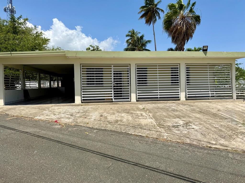 A single-story house with a carport and white security bars over the windows and doors — Carr 686 Km 0.2 CARR 686 KM 0.2 BO COTO NORTE SECTOR GUAYANEY, MANATI, PR