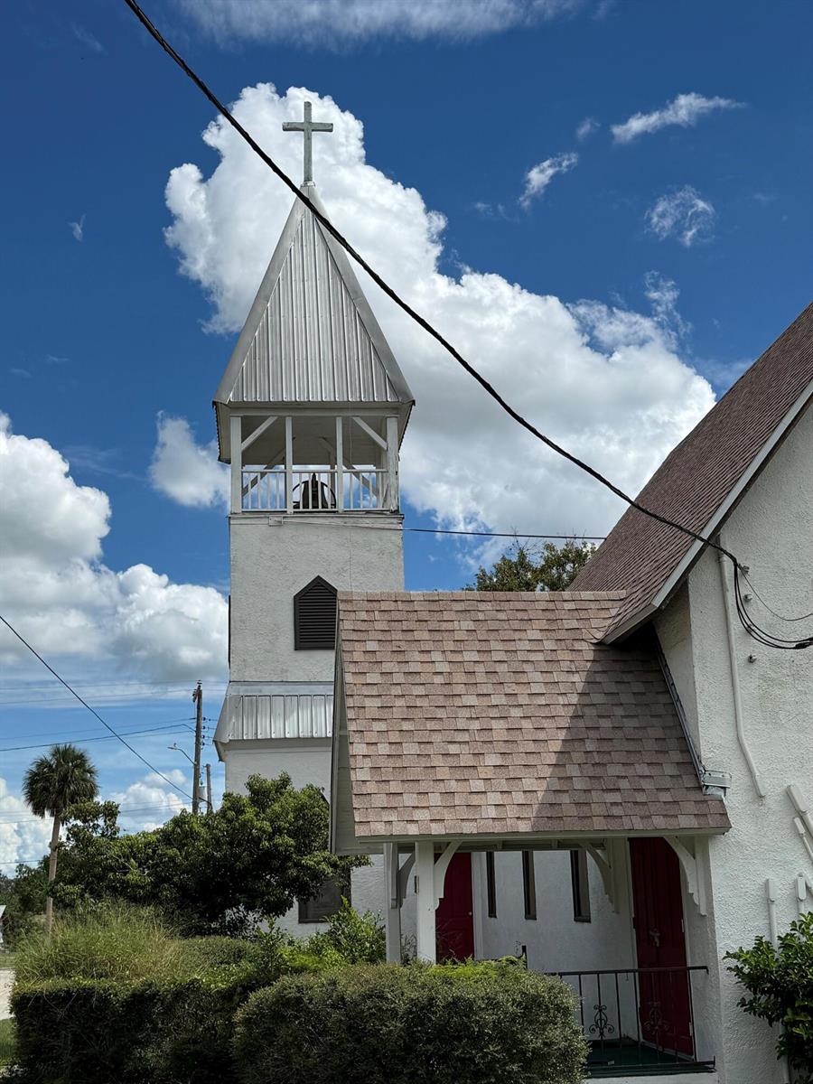 A white church building features a tall steeple with a cross and a shingled roof — 18 E Pleasant Street, FL 33825, FL
