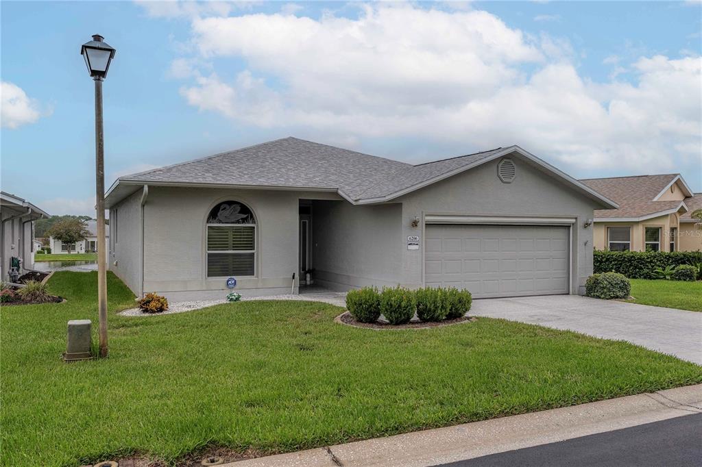 A single-story gray house with a two-car garage and a front lawn — 6206 RES CIRCLE, LAKELAND, FL