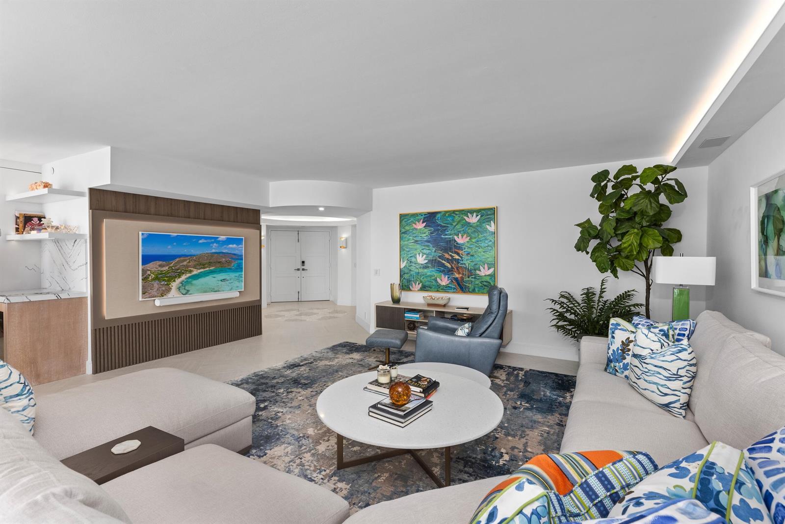 A modern living room features a large sectional sofa, a round coffee table, and a television — 1500 S Ocean Boulevard # 1505, Boca Raton FL 33432, BOCA RATON, FL