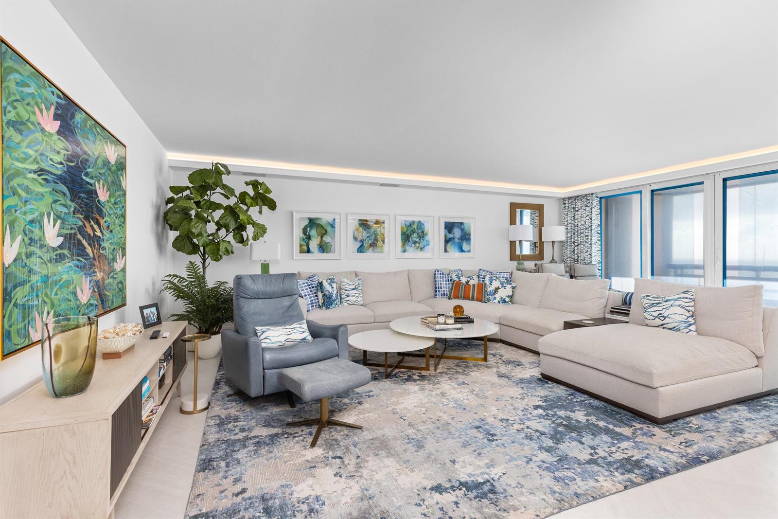 A living room features a large sectional sofa, a blue recliner, and abstract wall art — 1500 S Ocean Boulevard # 1505, Boca Raton FL 33432, BOCA RATON, FL
