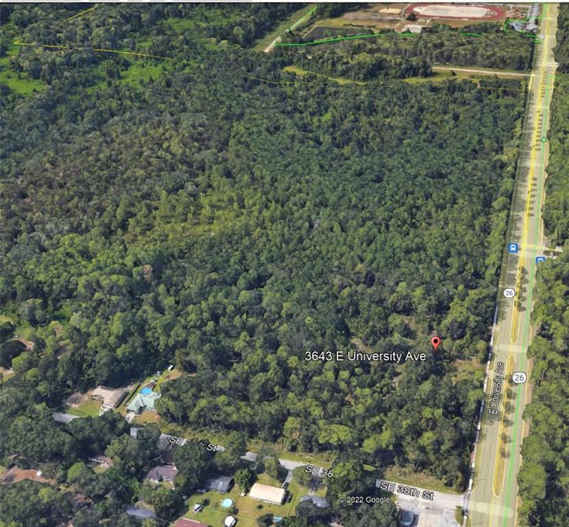An aerial view of a heavily wooded, undeveloped lot located along a main road — 3643 E UNIVERSITY AVENUE, GAINESVILLE, FL