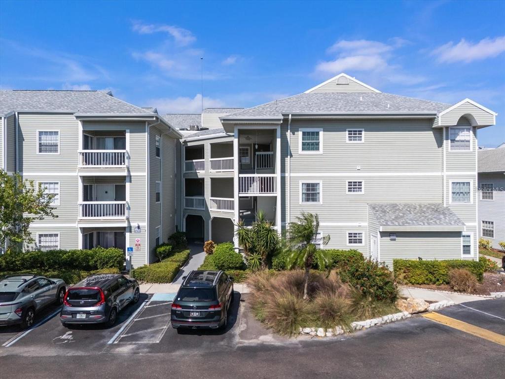 A three-story apartment building with light green siding and a central outdoor stairwell — 6826 STONES THROW CIRCLE N UNIT 11101, ST PETERSBURG, FL