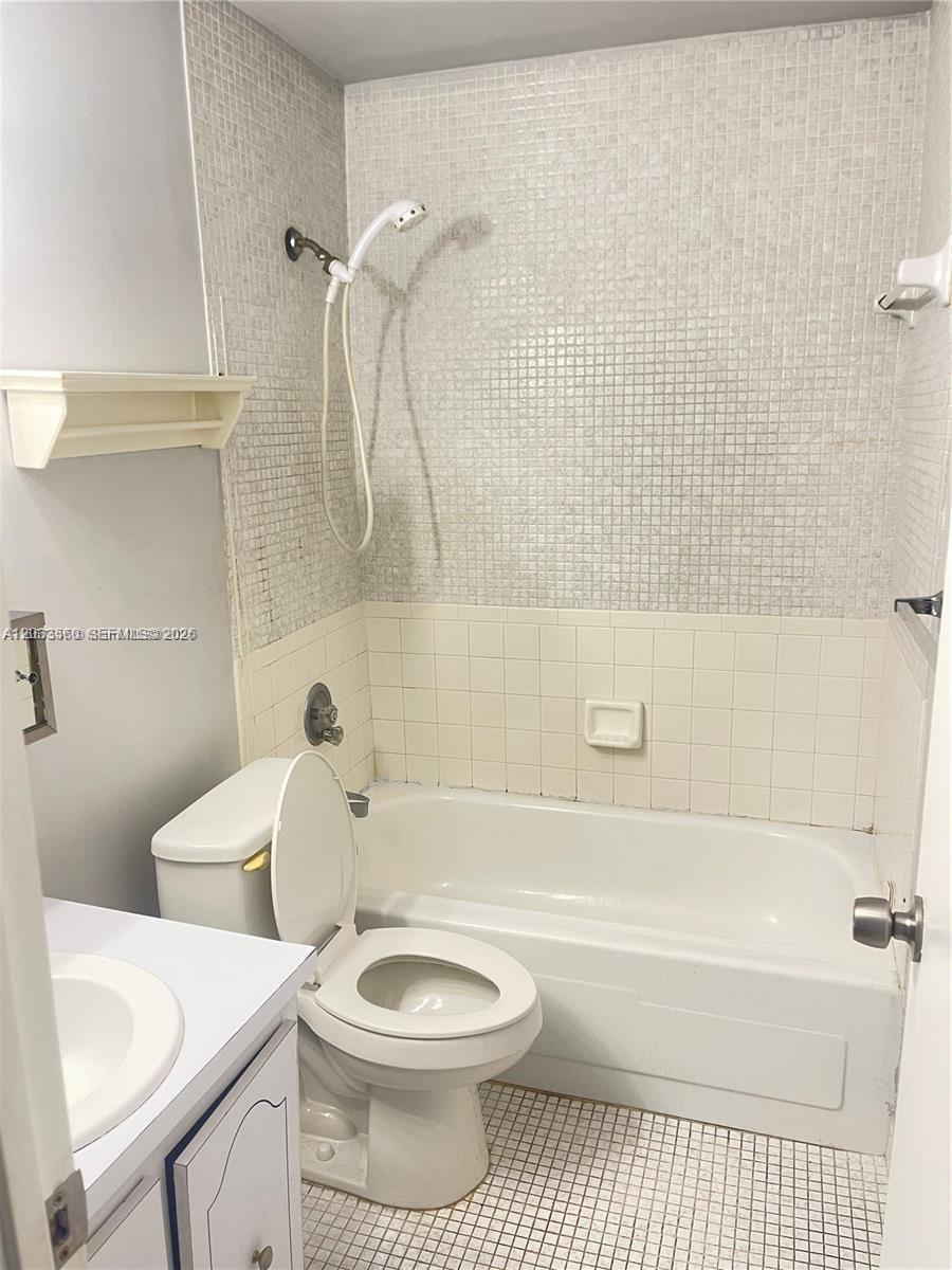 A bathroom features a white toilet, a bathtub with a showerhead, and tiled walls — 10383 N Kendall Dr # N5, Miami FL 33176, MIAMI, FL