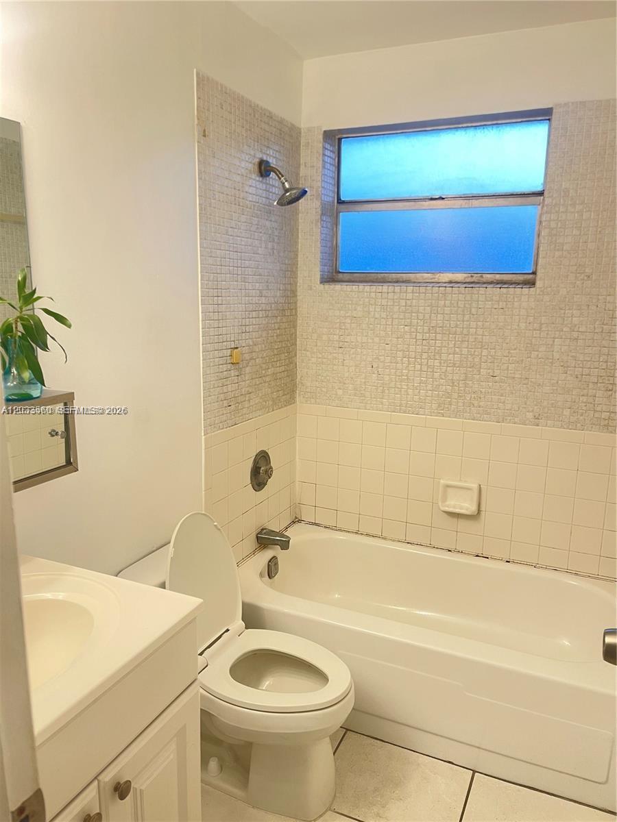 A bathroom features a white vanity, a toilet, and a bathtub with tiled walls — 10383 N Kendall Dr # N5, Miami FL 33176, MIAMI, FL