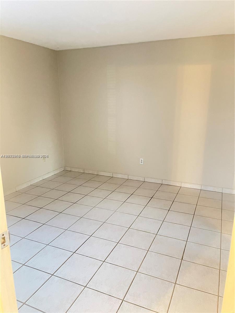 An empty room features beige walls and light-colored square floor tiles — 10383 N Kendall Dr # N5, Miami FL 33176, MIAMI, FL