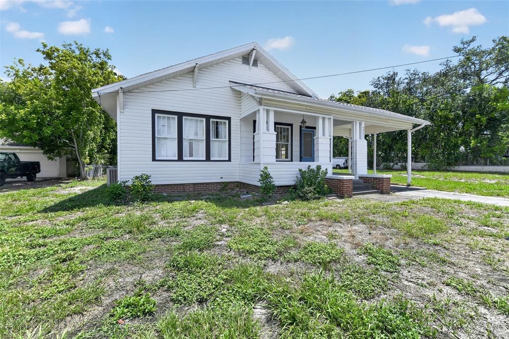A white, single-story house with a front porch and a large, grassy yard — 2233 11TH AVENUE W, BRADENTON, FL