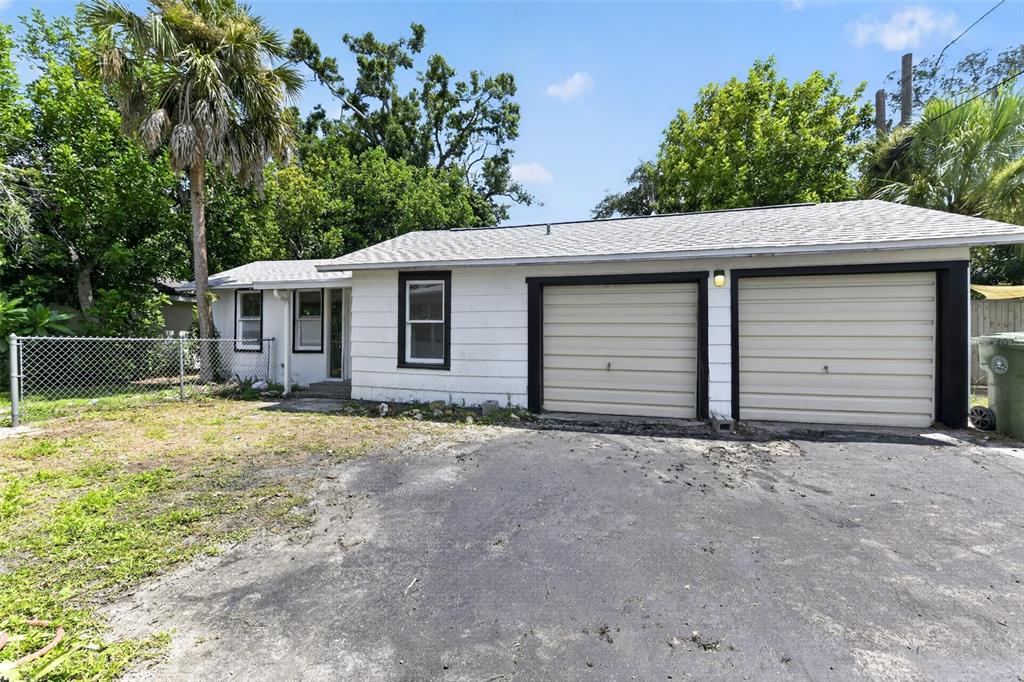 A white, single-story house with a two-car garage and a chain-link fence — 2233 11TH AVENUE W, BRADENTON, FL