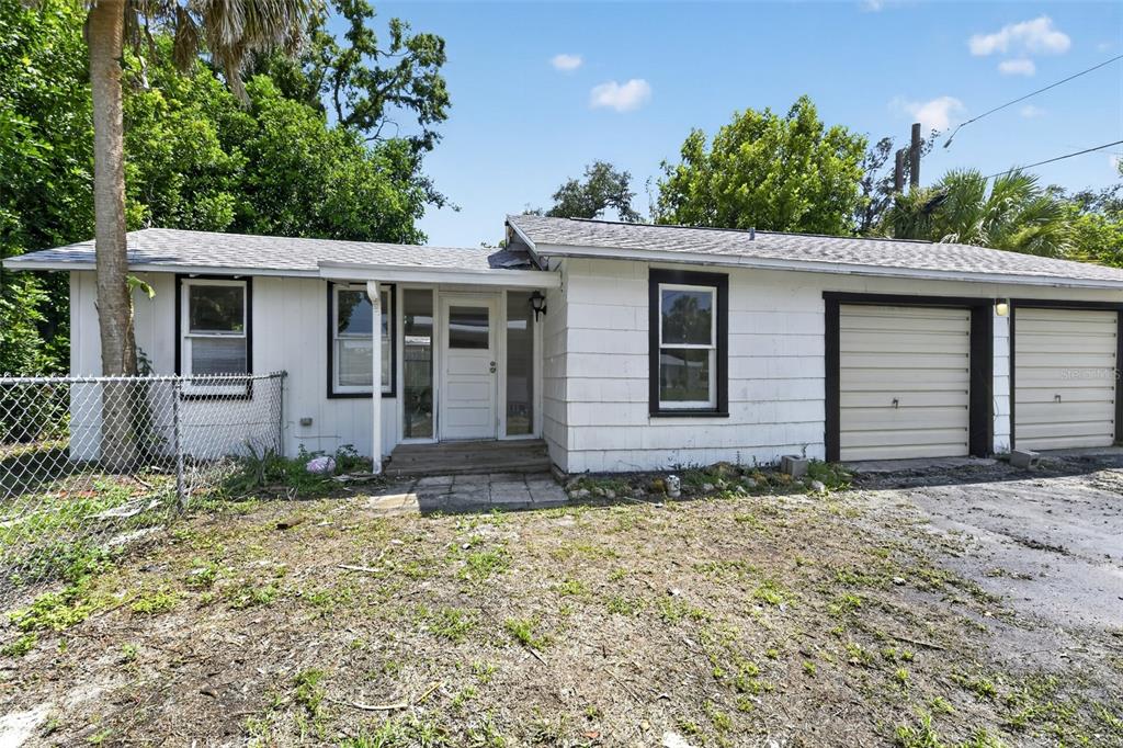 A single-story white house with a two-car garage and a chain-link fence — 2233 11TH AVENUE W, BRADENTON, FL
