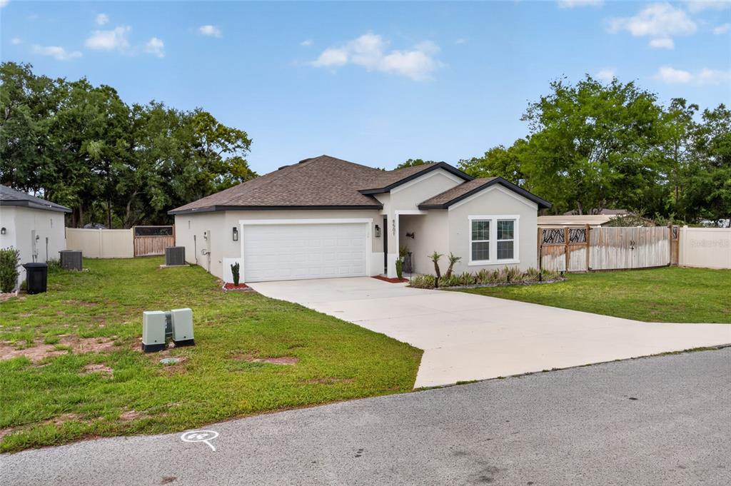 A single-story house with a white stucco exterior, a two-car garage, and a concrete driveway — 8501 SE 160TH PLACE, SUMMERFIELD, FL