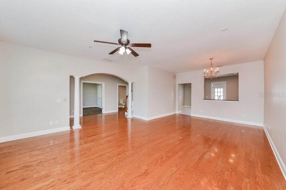 An empty living room with hardwood floors, a ceiling fan, and an arched entryway — 204 ABERDEEN POND DRIVE, APOLLO BEACH, FL