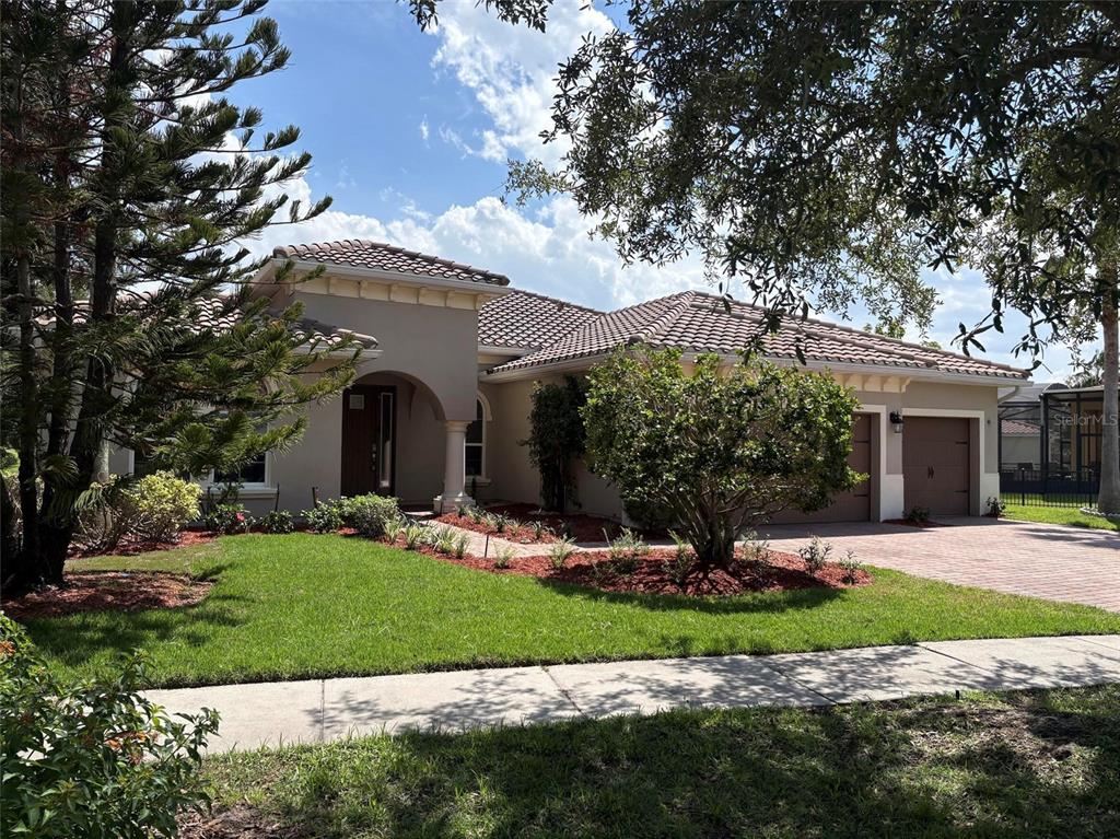 A single-story house with a tiled roof, arched entryway, and a two-car garage — 3700 PARADISO CIRCLE, KISSIMMEE, FL