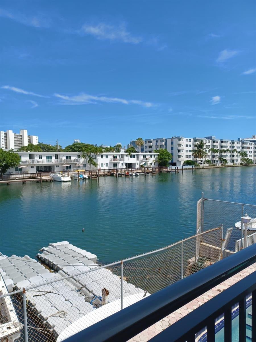 A view of a canal with boats docked in front of white apartment buildings — 8001 N Crespi Boulevard # 2c, Miami Beach FL 33141, MIAMI BEACH, FL