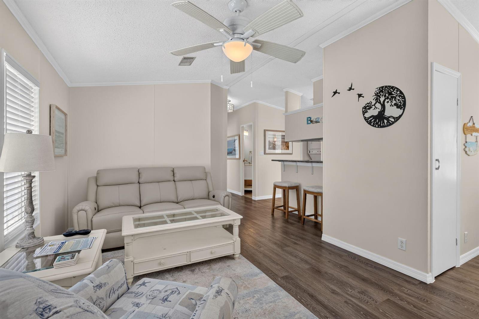 A living room features a light-colored sofa, a coffee table, and a breakfast bar area — 351 Nettles Boulevard, Jensen Beach FL 34957, JENSEN BEACH, FL