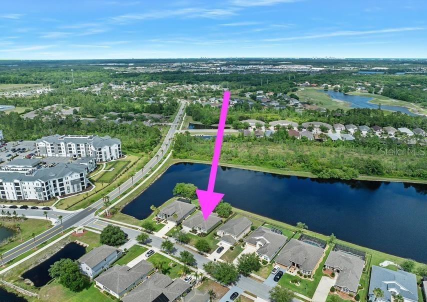 An aerial view shows a residential neighborhood with a pink arrow pointing to a house — 361 PERFECT DRIVE, DAYTONA BEACH, FL