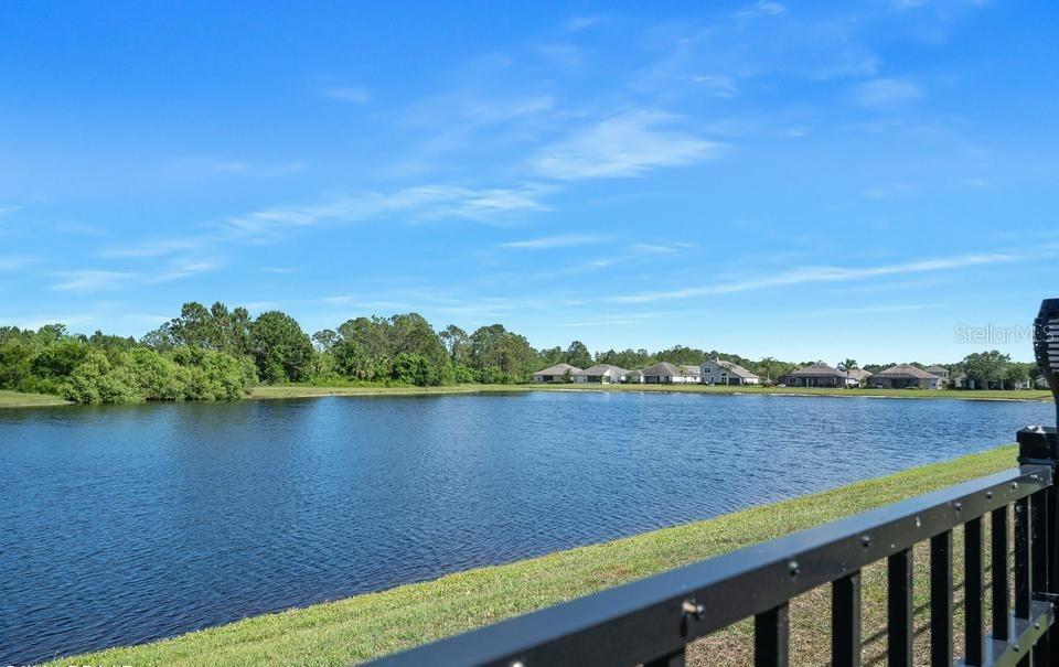 A view of a lake and distant houses from a fenced patio — 361 PERFECT DRIVE, DAYTONA BEACH, FL