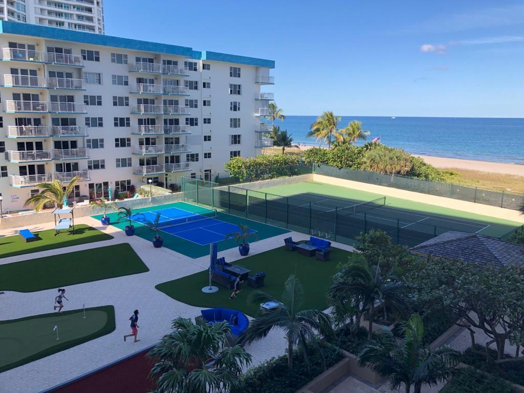 An elevated view of a coastal apartment building with tennis courts, putting greens, and ocean views — 1800 S Ocean Boulevard # 403, Pompano Beach FL 33062, POMPANO BEACH, FL
