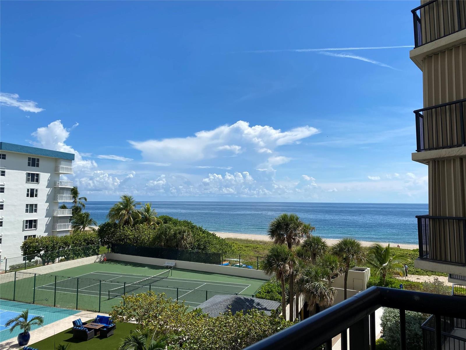 A high-angle view shows a tennis court, palm trees, a beach, and the ocean — 1800 S Ocean Boulevard # 403, Pompano Beach FL 33062, POMPANO BEACH, FL