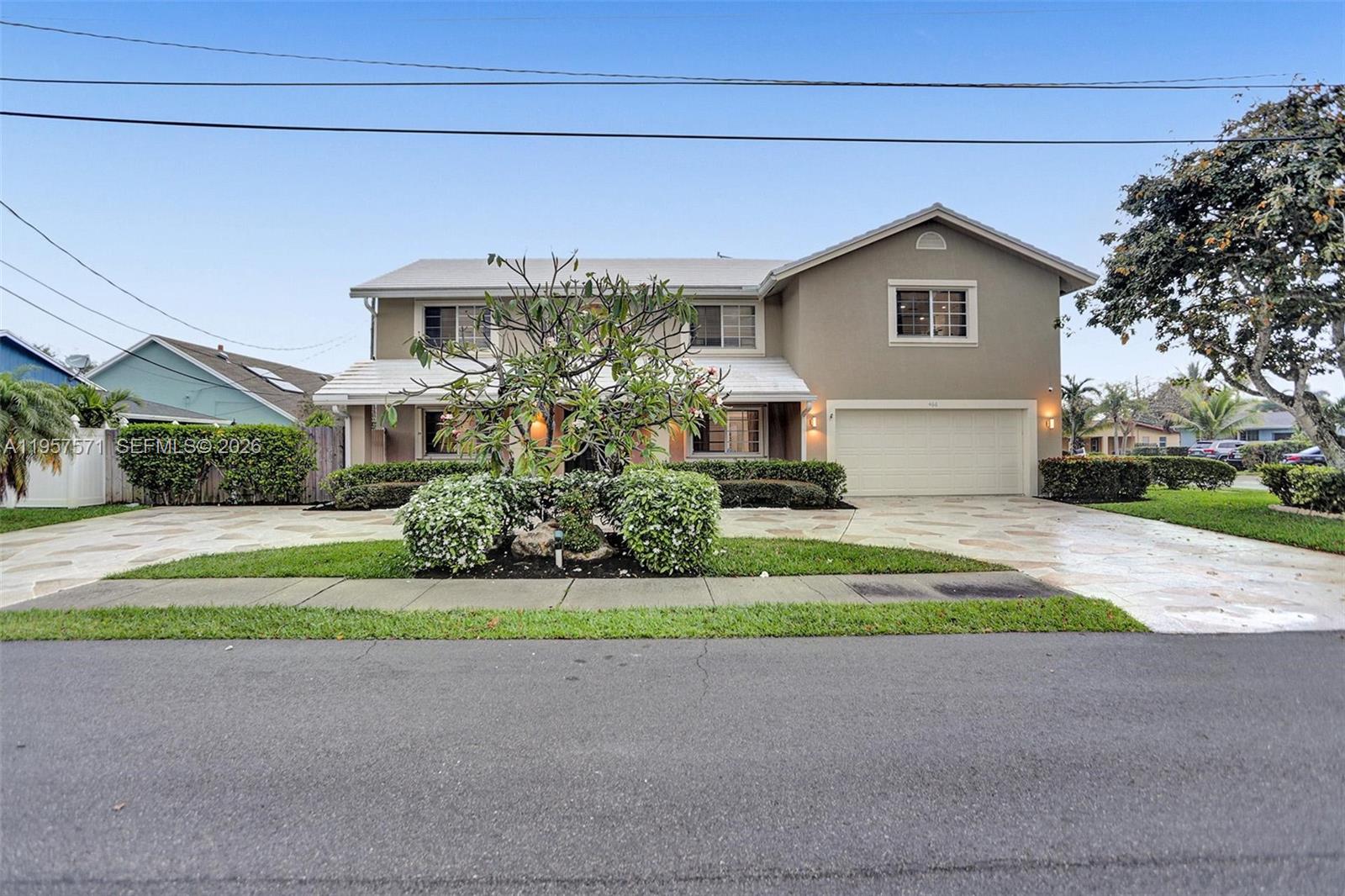 A two-story house with a beige exterior, a stone driveway, and a front garden — 466 NE 8th Ave, Deerfield Beach FL 33441, DEERFIELD BEACH, FL