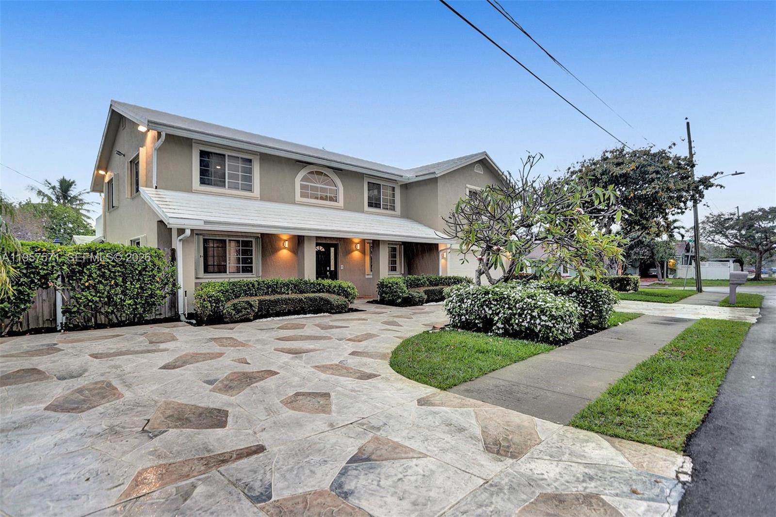 A two-story house features a stone-patterned driveway, a covered porch, and manicured landscaping — 466 NE 8th Ave, Deerfield Beach FL 33441, DEERFIELD BEACH, FL