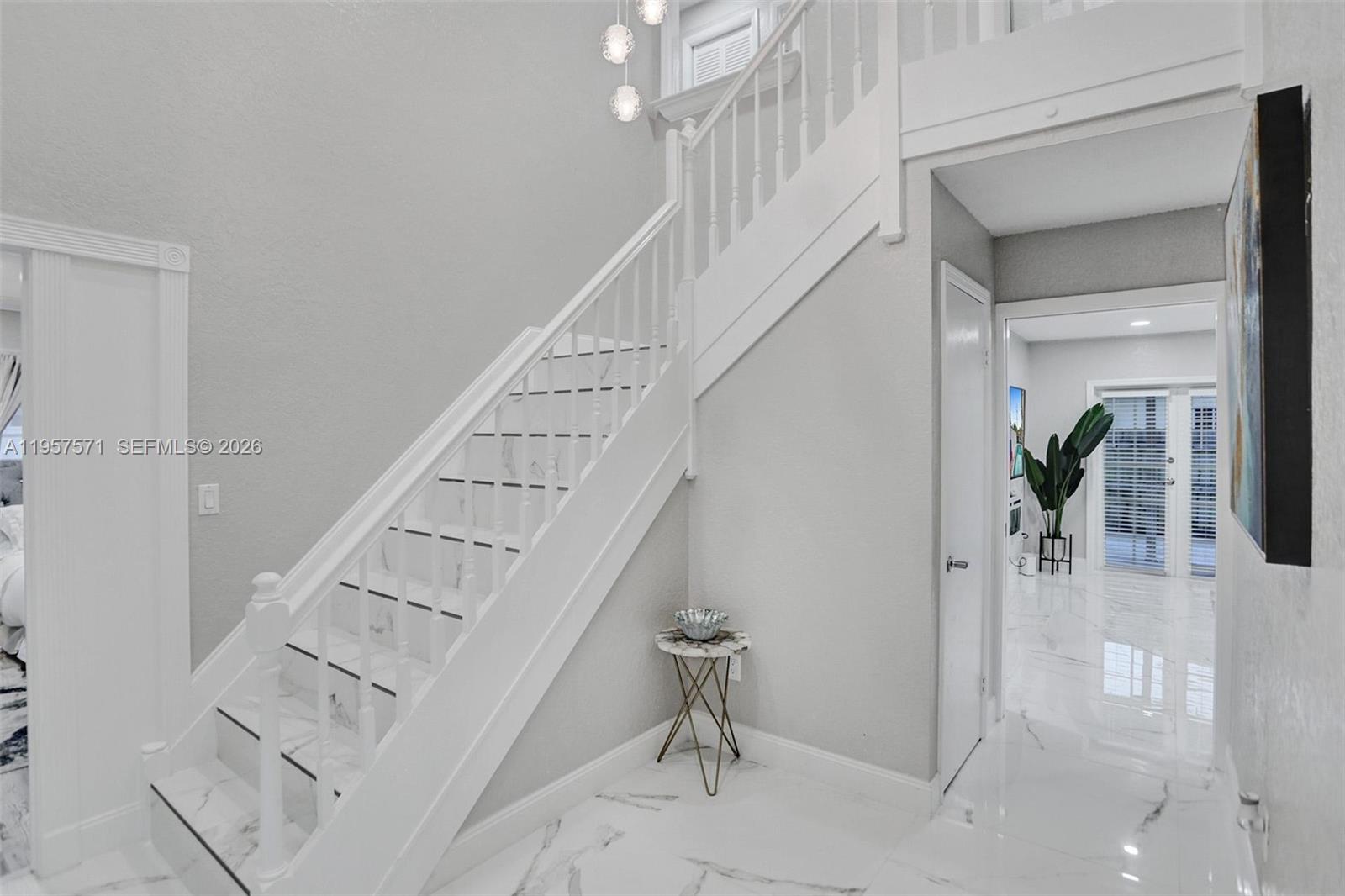 A white staircase with marble steps leads upward in a bright, modern foyer — 466 NE 8th Ave, Deerfield Beach FL 33441, DEERFIELD BEACH, FL