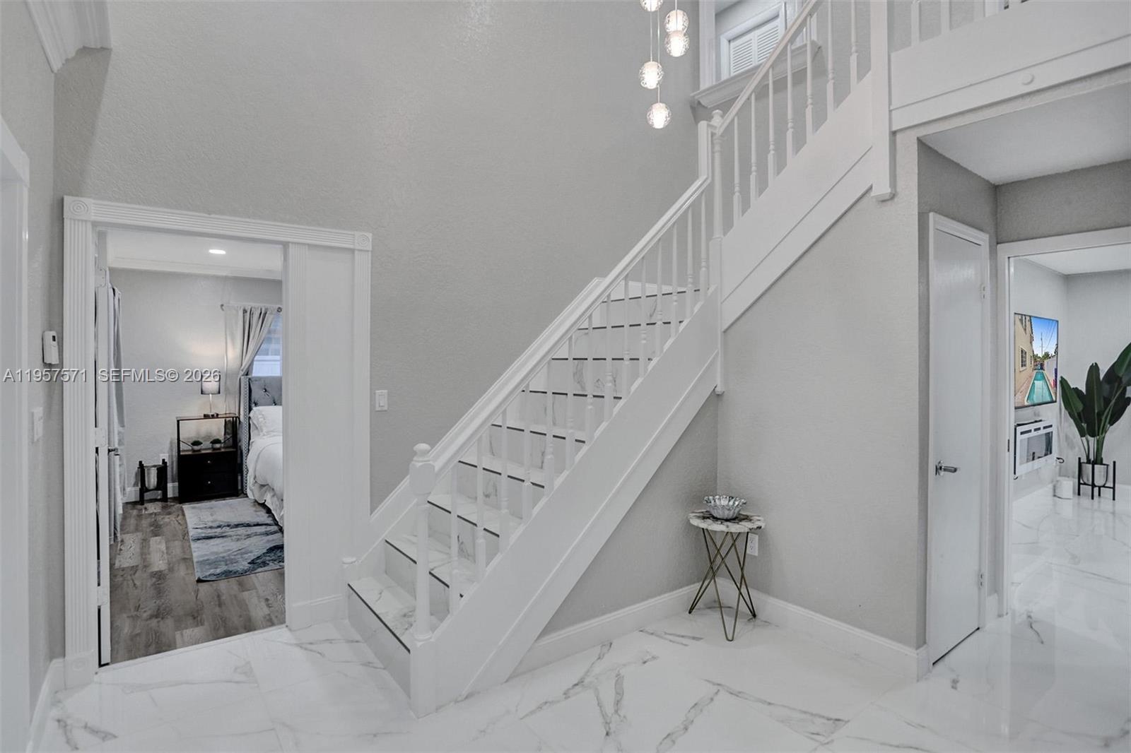 A foyer features white marble floors, a staircase with white railings, and two doorways — 466 NE 8th Ave, Deerfield Beach FL 33441, DEERFIELD BEACH, FL