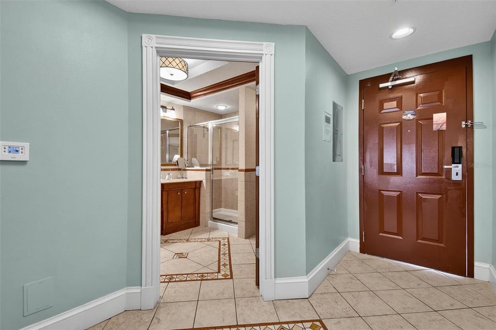 An entryway with light blue walls, tile flooring, and a doorway leading into a bathroom — 200 OCEAN CREST DRIVE UNIT 924, PALM COAST, FL