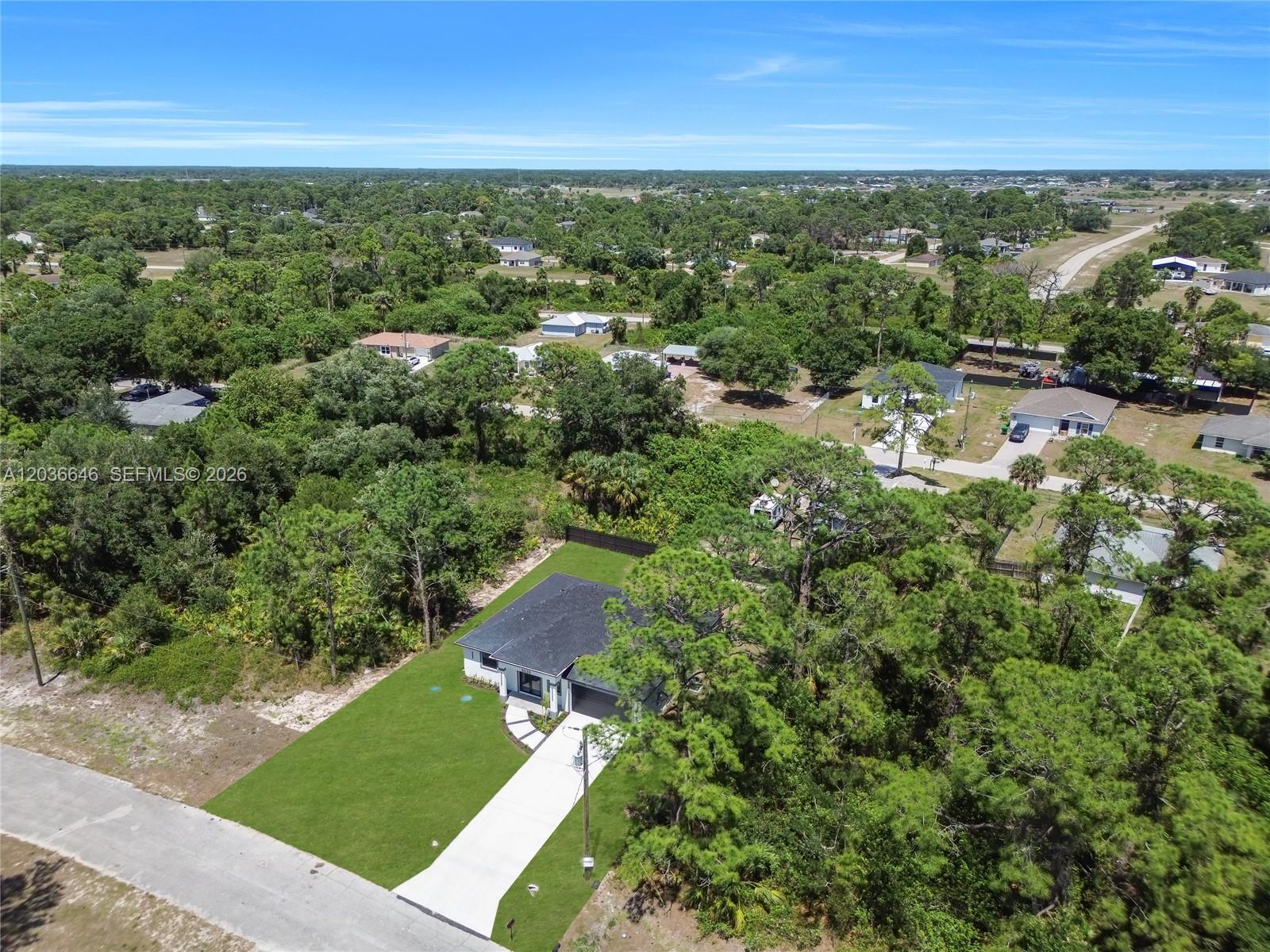 An aerial view shows a single-story house with a dark roof and driveway — 5035 Spinnaker RD, La Belle FL 33935, LA BELLE, FL