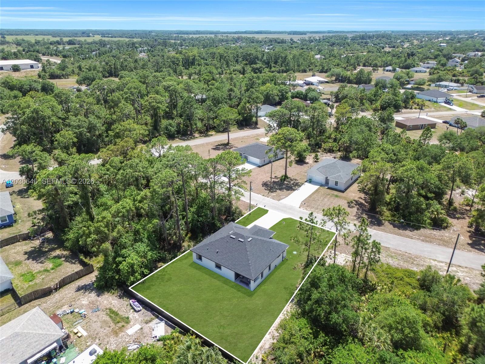 An aerial view shows a single-story house with a dark roof and a fenced yard — 5035 Spinnaker RD, La Belle FL 33935, LA BELLE, FL