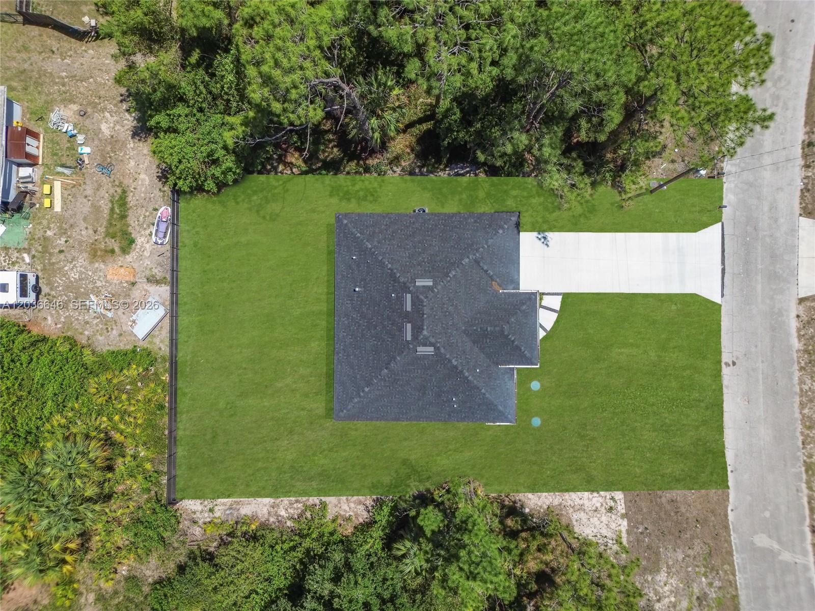 An aerial view shows a house with a dark roof centered on a grassy lot — 5035 Spinnaker RD, La Belle FL 33935, LA BELLE, FL