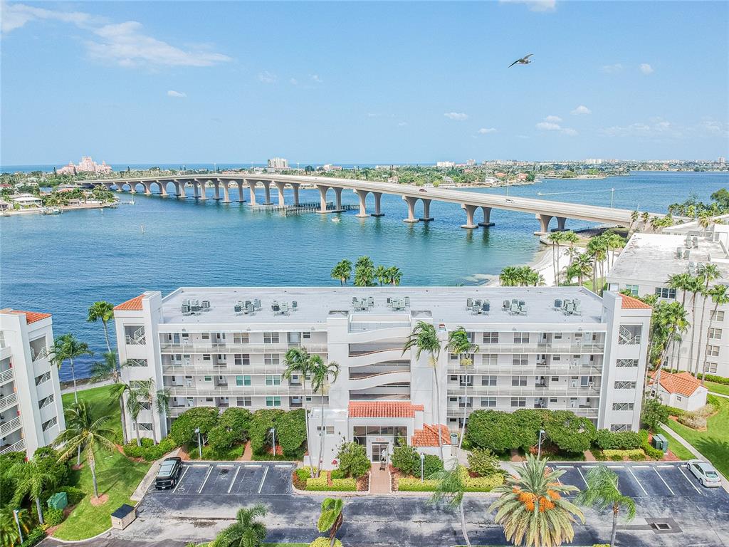 An aerial view shows a multi-story apartment building with a parking lot near a bridge — 5901 BAHIA DEL MAR CIRCLE UNIT 518, ST PETERSBURG, FL