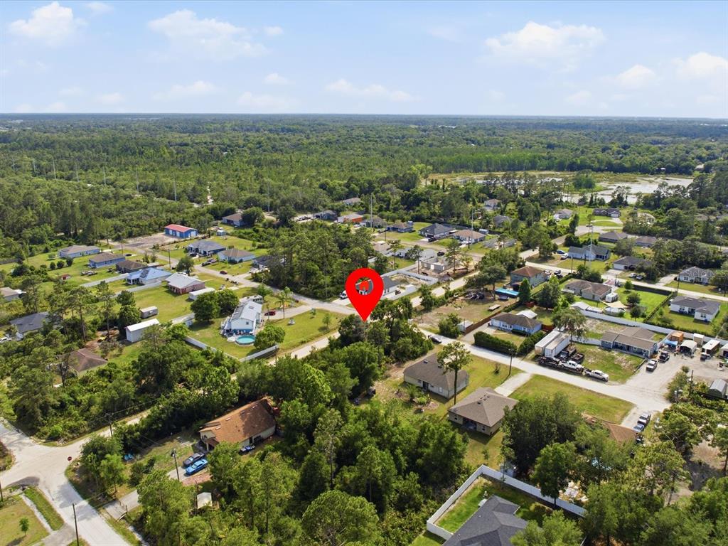 An aerial view shows a residential neighborhood with a red location pin marking a lot — 1001 10TH AVENUE, DELAND, FL