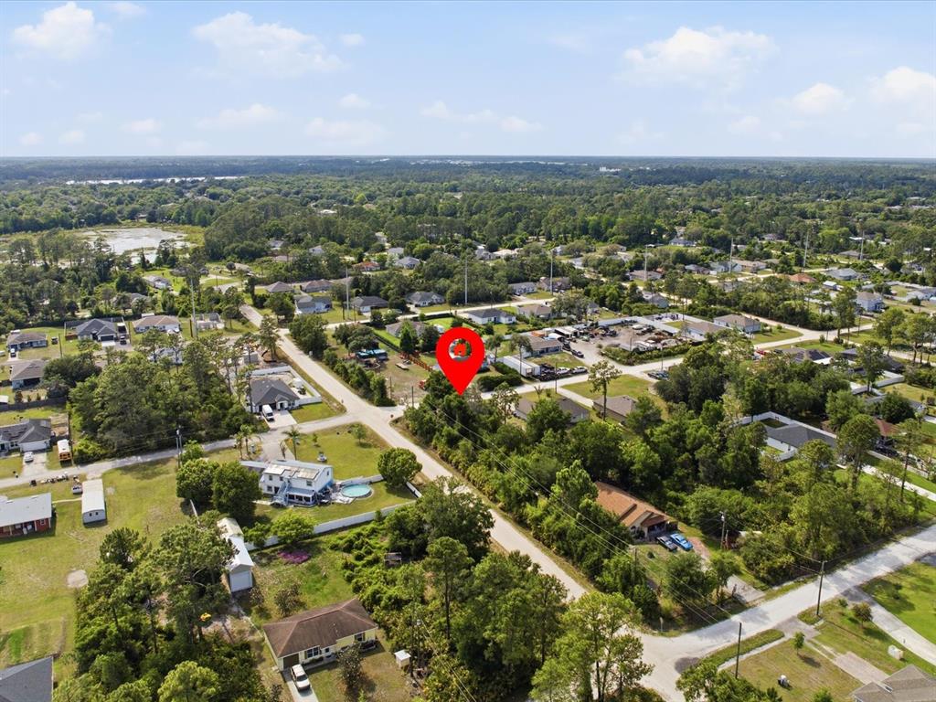 An aerial view shows a red location pin over a wooded residential lot — 1001 10TH AVENUE, DELAND, FL