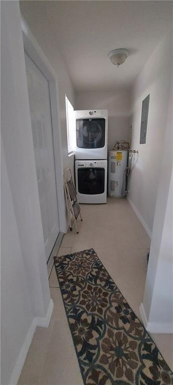 A laundry room features a stacked washer and dryer, a water heater, and tile flooring — 738 SW 5th Avenue, Hallandale Beach FL 33009, HALLANDALE BEACH, FL