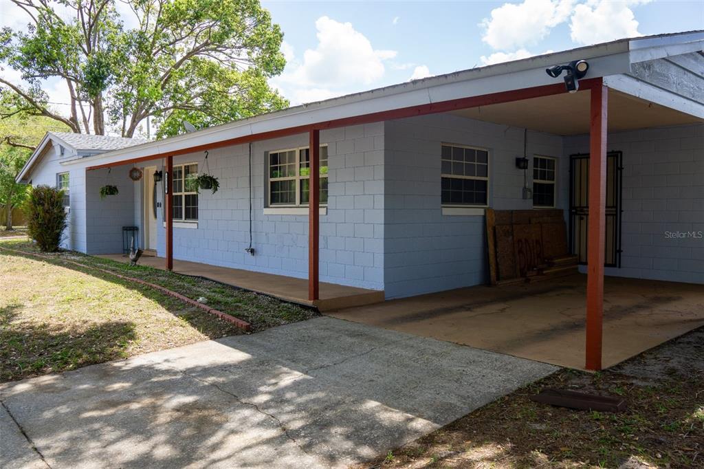 A light blue concrete block house features a covered front porch and an attached carport — 5350 INCA STREET, ORLANDO, FL