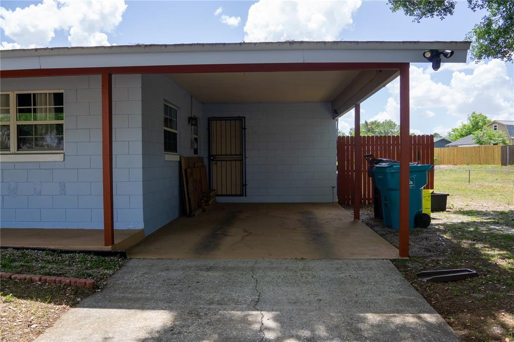 A light blue concrete block house features a covered carport with a concrete driveway — 5350 INCA STREET, ORLANDO, FL
