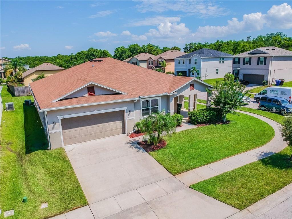 An aerial view of a single-story suburban house with a tan exterior and brown roof — 1501 ANGLER AVENUE, KISSIMMEE, FL