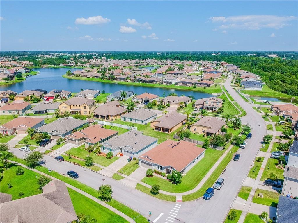 An aerial view of a suburban neighborhood featuring houses, a large pond, and paved streets — 1501 ANGLER AVENUE, KISSIMMEE, FL