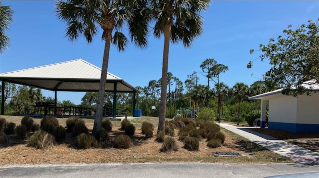 A park area features a covered picnic pavilion, a playground, and a small building — 13232 KITCHENER AVENUE, PORT CHARLOTTE, FL