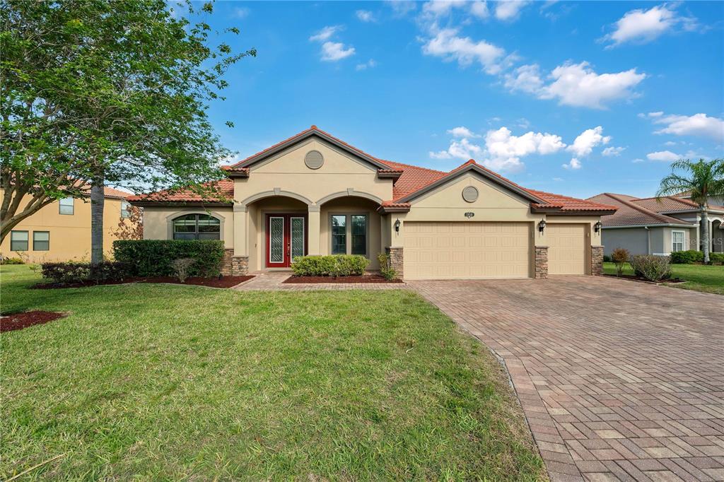 A single-story house with a tile roof, a two-car garage, and a large front tree — 3950 SUNSET LAKE DRIVE, LAKELAND, FL